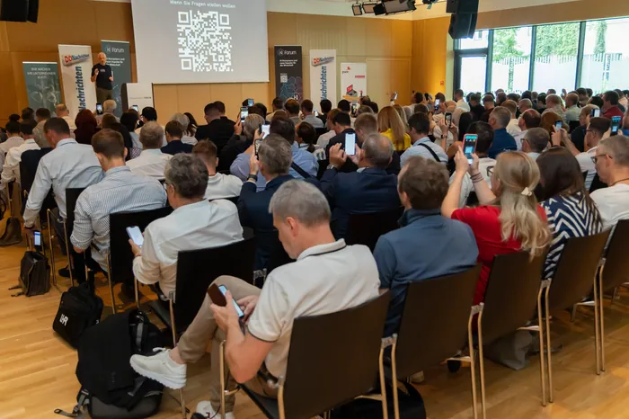 Packed audience capturing moments on mobile phones