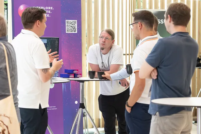 Exhibition booth discussion with tech displays